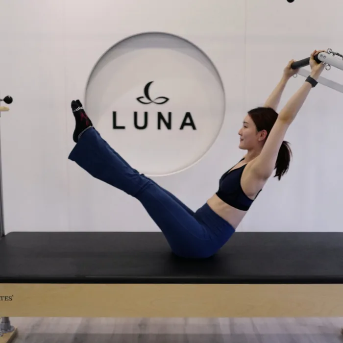 A client on the mat at the Rama 2 studio, with the Luna mark on the wall behind